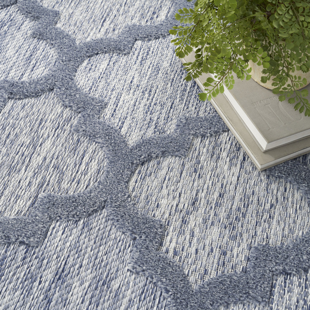 Blue indoor outdoor area rug corner with textured looped surface and trellis pattern