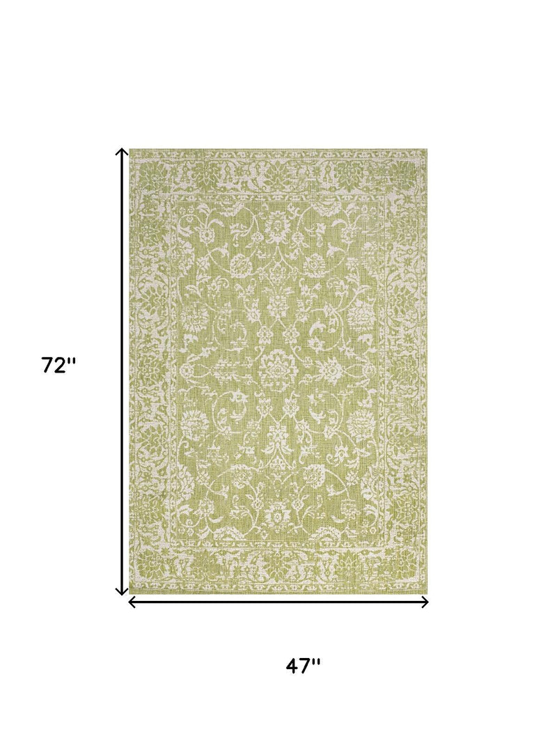 Indoor area rug in green and cream, medallion motif; 47 in x 72 in