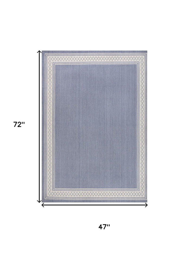 Blue rectangular area rug with cream border; 47 in by 72 in dimensions