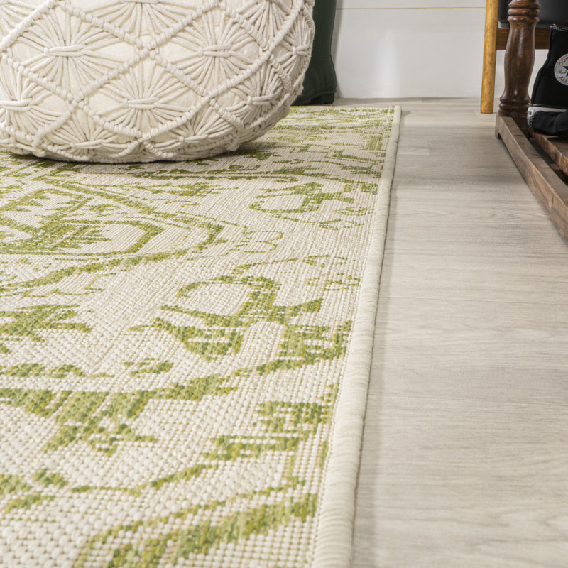 Cream and green medallion runner rug corner with braided border detail