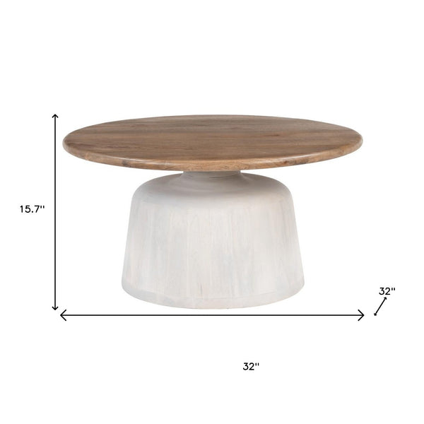Round pedestal coffee table with brown solid wood top and white cylindrical base