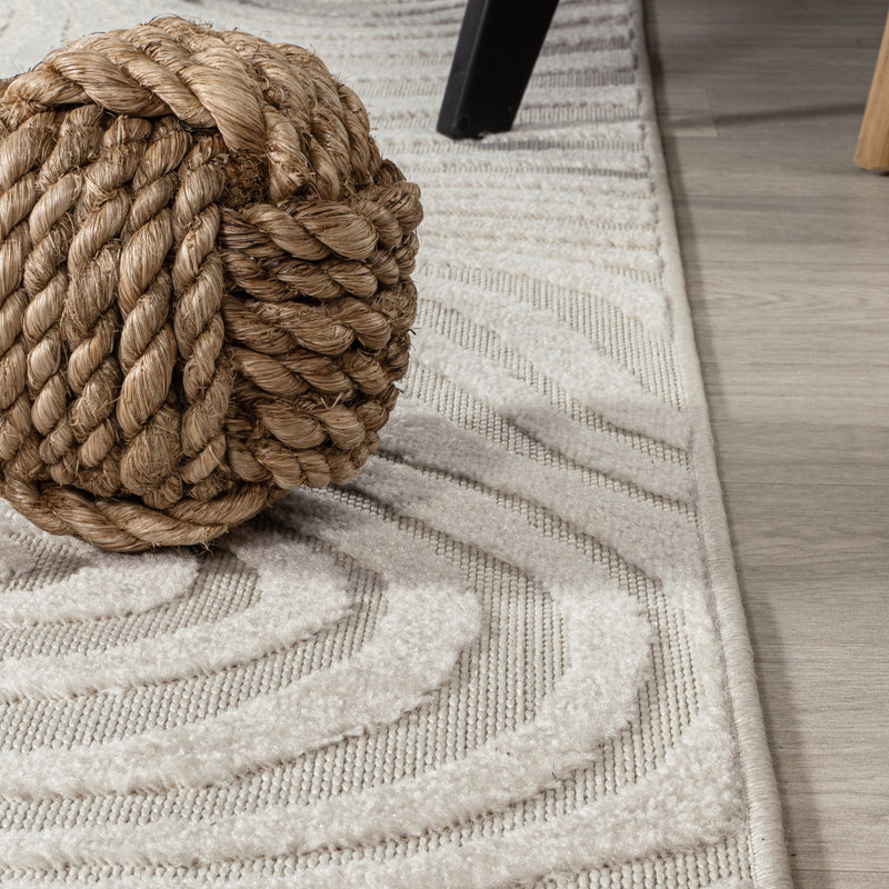 Cream and ivory striped area rug with textured loops and wavy abstract lines.