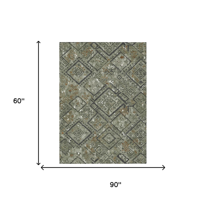 Sized view of green geometric area rug with dark diamond pattern and orange accent flecks