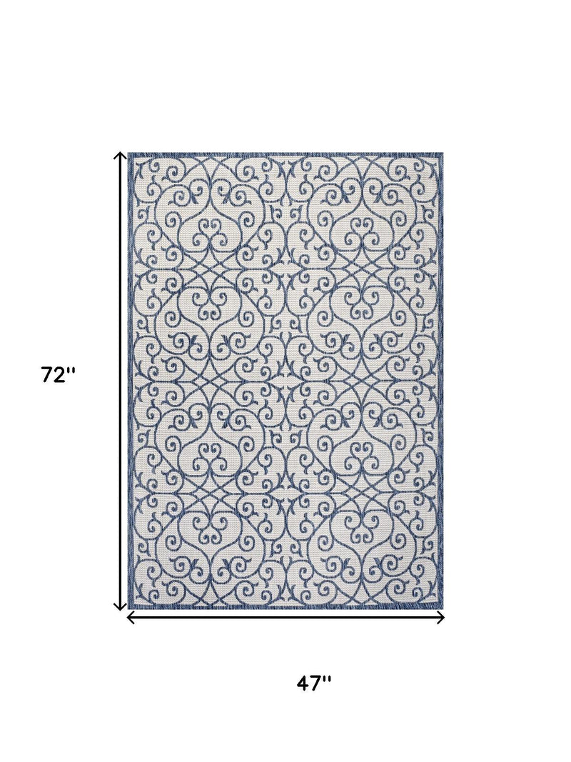 Geometric area rug, cream and blue scroll pattern; 4 ft x 6 ft