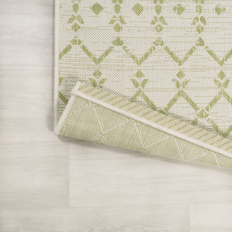 Cream and green trellis runner rug corner with diamond pattern border detail