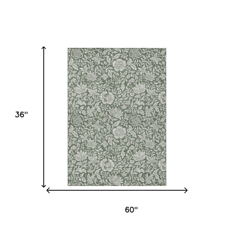 Green rug with ivory floral pattern, size 60 in x 36 in.
