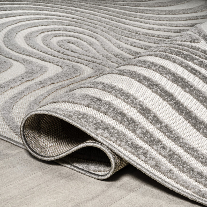 Gray and ivory indoor outdoor rug with bound edge and low textured pile