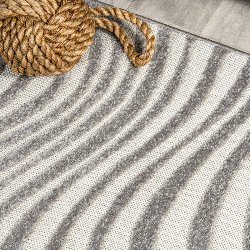 Gray and ivory square rug with braided rope-like trim at the corner