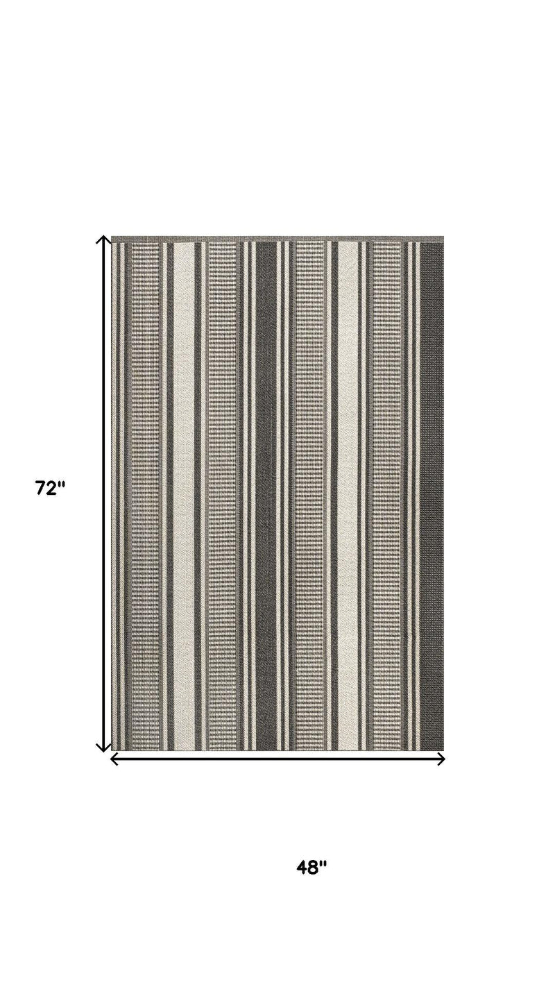 Indoor/outdoor area rug, black and cream vertical stripes with thin border