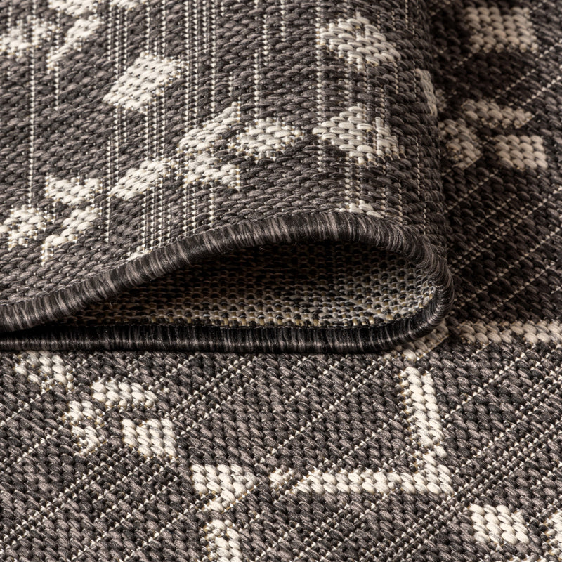 Round black and gray trellis indoor/outdoor area rug, low-pile with braided border edge