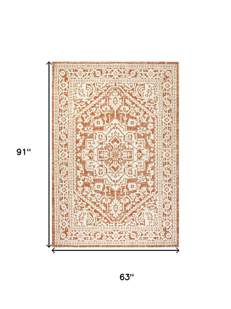 Orange and cream medallion rug, 63 x 91 in, decorative border and center pattern