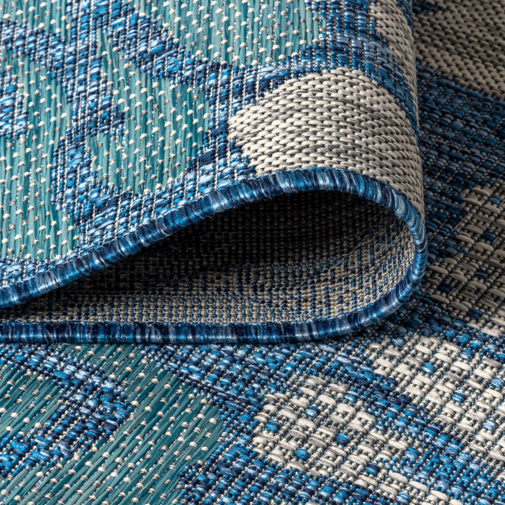 Textured blue-and-cream rug weave with stitched border and rolled edge