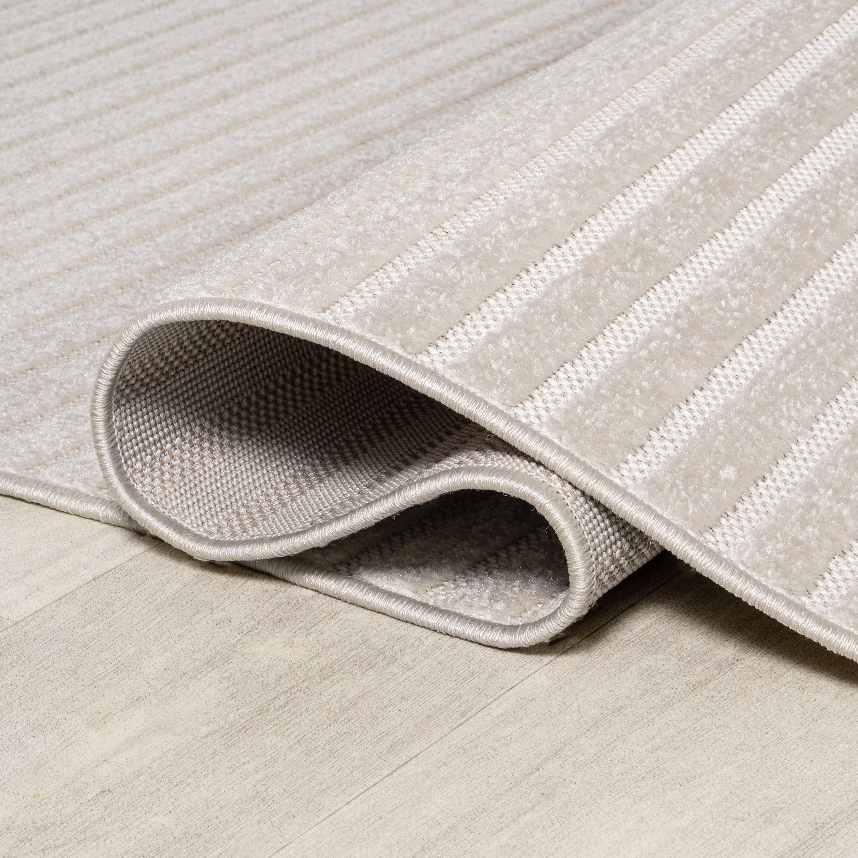 Ivory and cream rug with stitched edge and low-profile woven underside