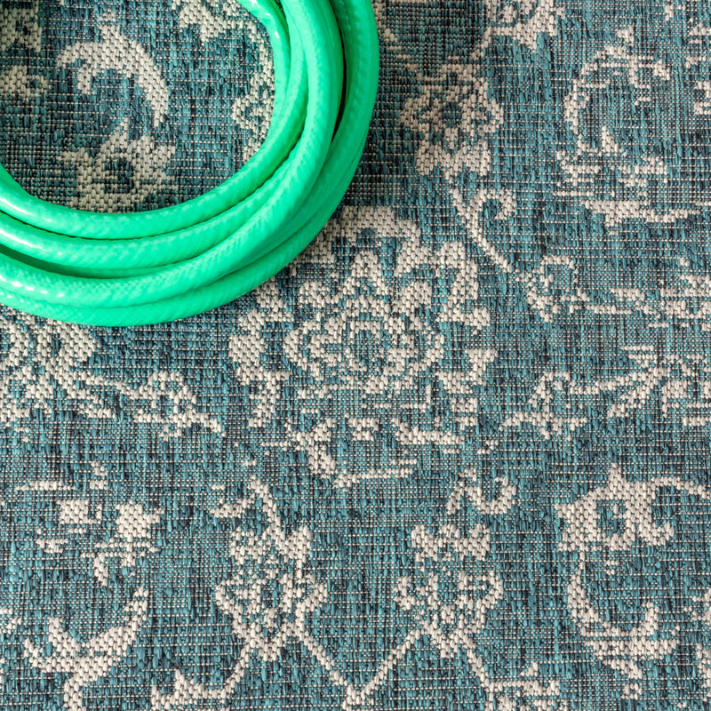 Close-up of teal and gray rug texture with white medallion motif