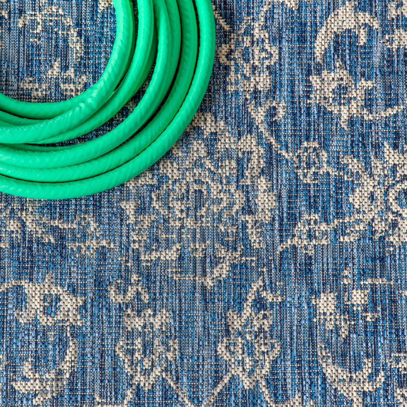 Navy and gray rug close-up with distressed medallion motifs and textured weave