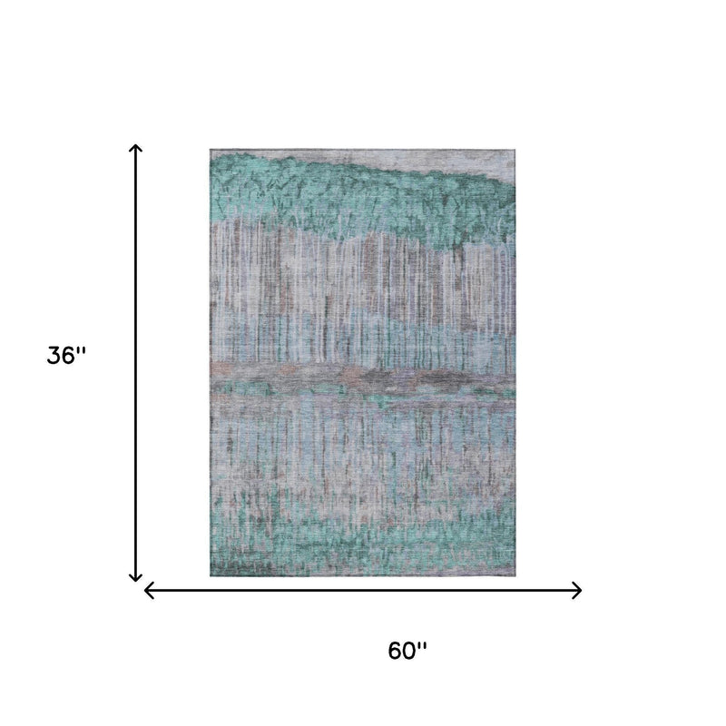 Rectangular area rug measuring 60 in x 36 in with teal and taupe abstract pattern