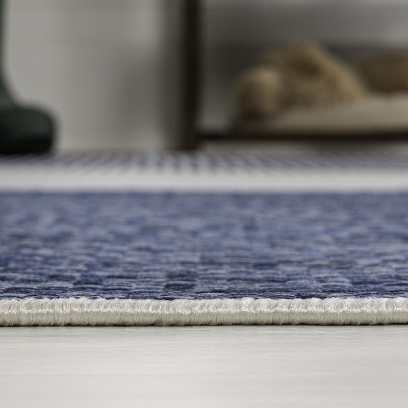Cream and navy geometric area rug with blue border and short fringe edge