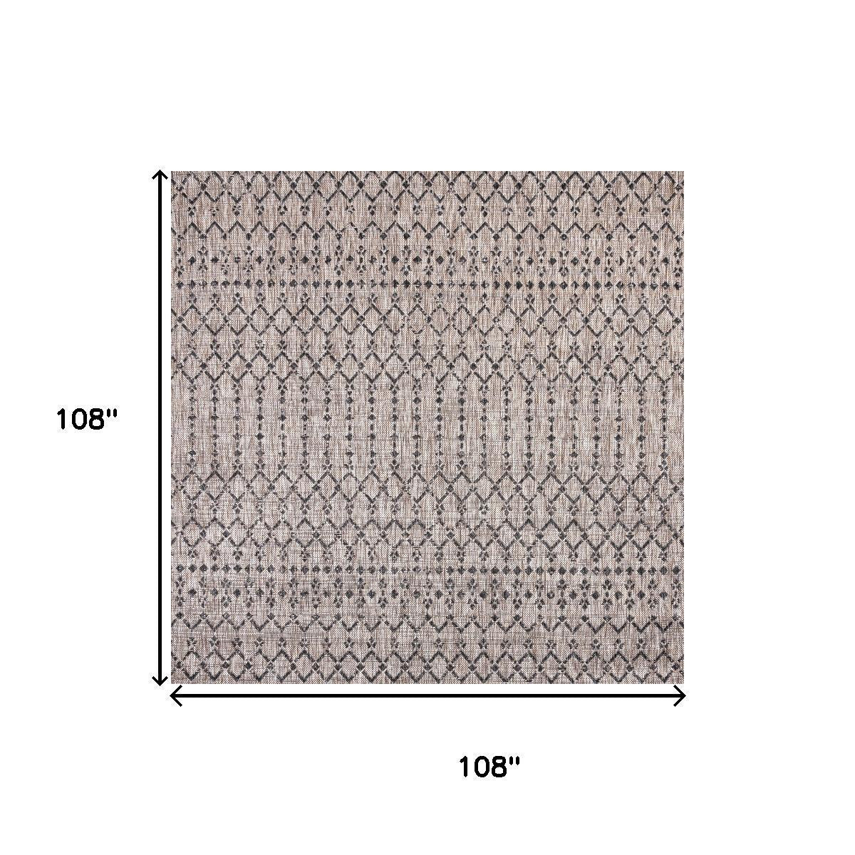 Indoor-outdoor area rug in beige with black diamond trellis pattern and flat woven face