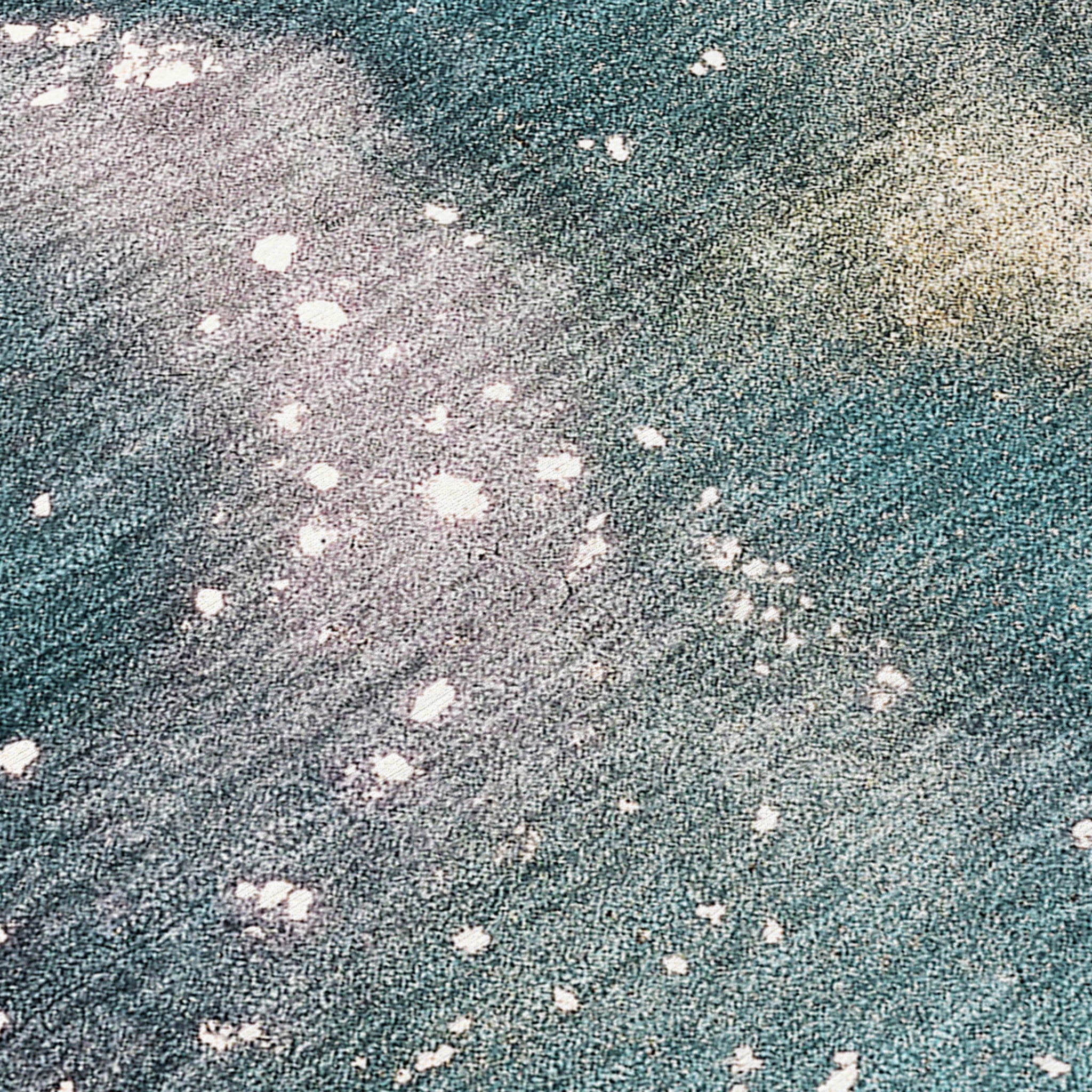Teal rug surface detail with scattered white speckles on distressed beige areas