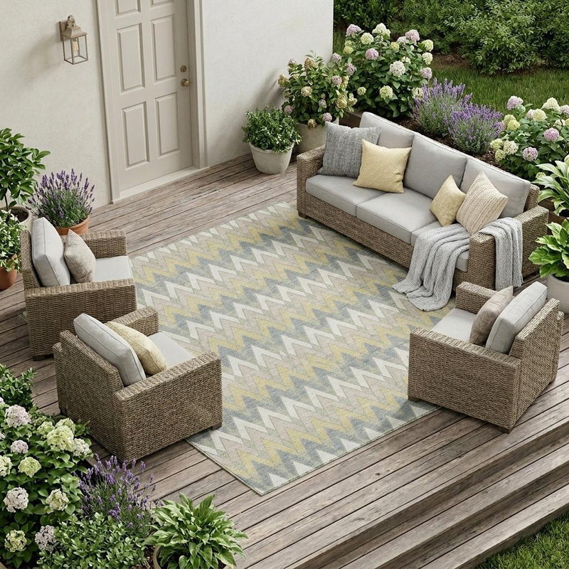 Outdoor area rug with repeating chevron pattern in ivory, beige, and blue-gray tones