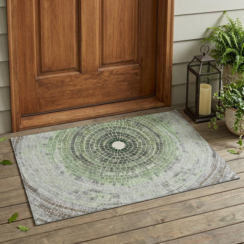 Geometric washable area rug with circular mosaic design in green and light gray on wood floor