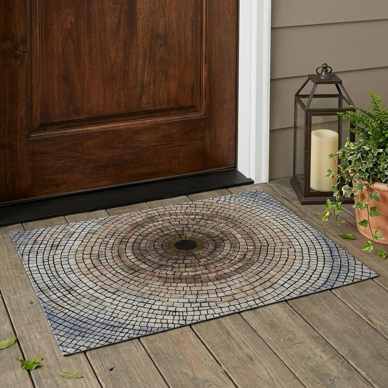 Beige and taupe geometric mosaic area rug laid on wood floor, circular center pattern
