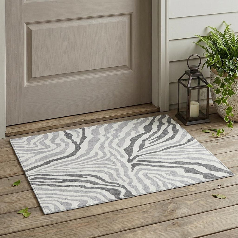 Gray and ivory zebra print indoor outdoor area rug, rectangular with flat border.