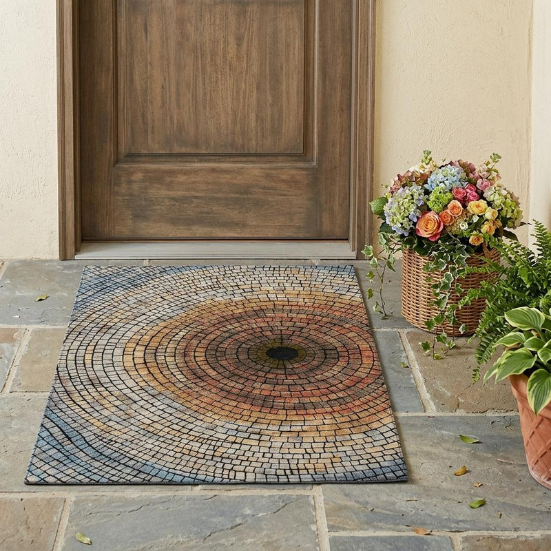 Geometric mosaic area rug with concentric brick rings in cream, blue-gray, and copper