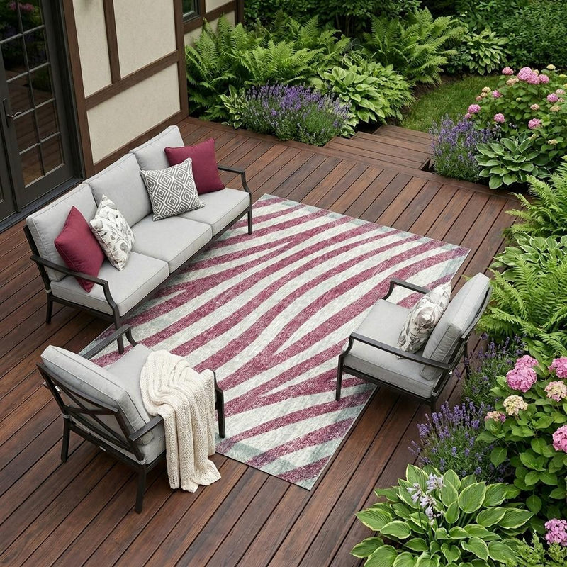 Pink and ivory zebra stripe indoor outdoor area rug laid on a deck floor