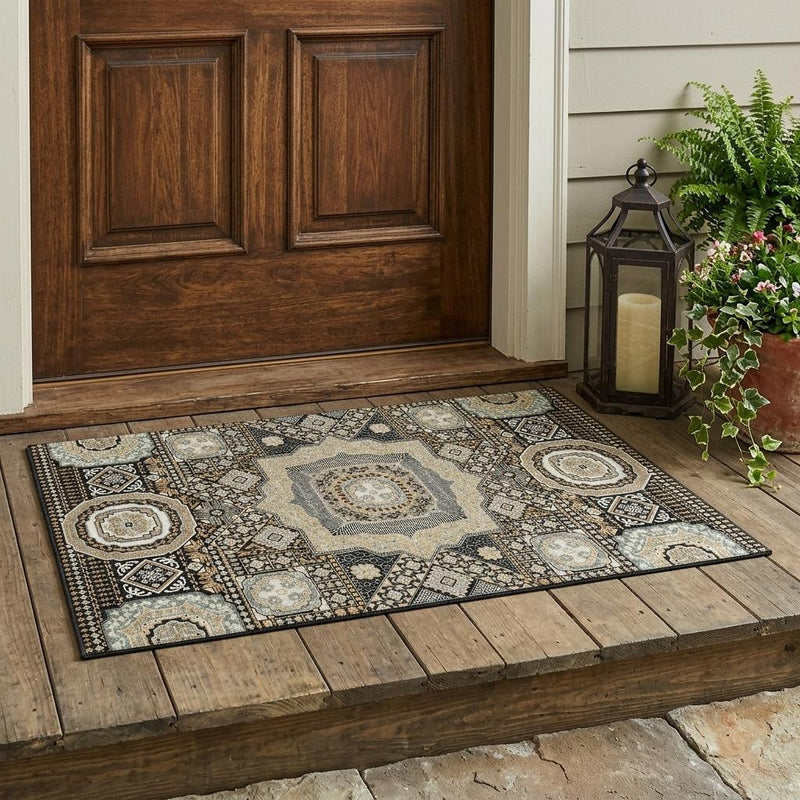 Oriental area rug laid on wood floor, black and ivory geometric medallion pattern