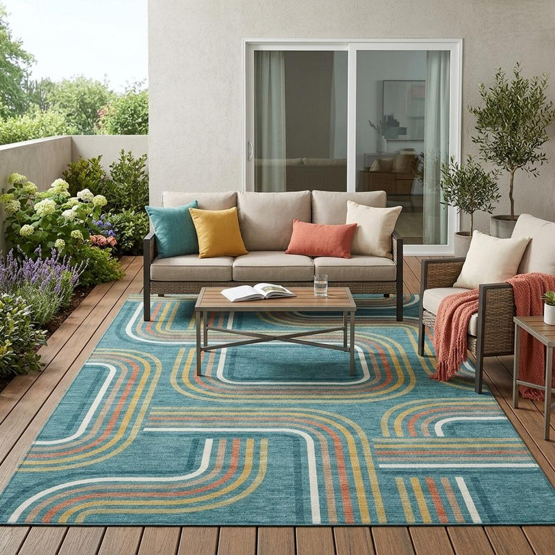 Teal blue geometric area rug with ivory and tan swirl lines in living room setting.