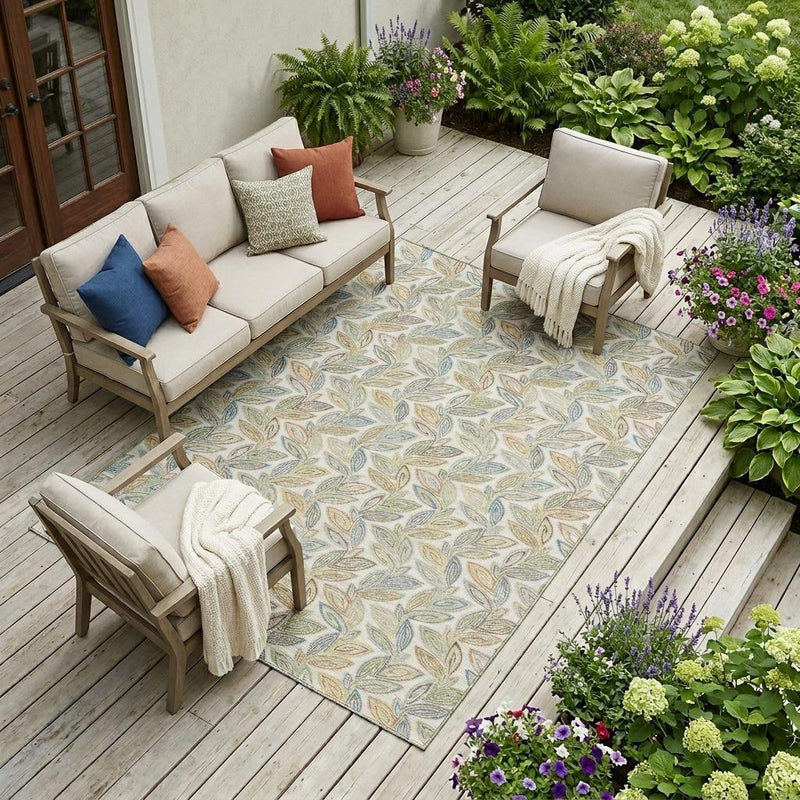 Indoor/outdoor ivory area rug with botanical leaf pattern in beige, blue, and green tones.