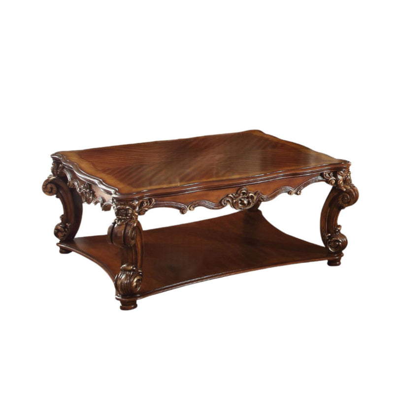 Brown wood coffee table featuring two shelves, decorative scrollwork apron, and carved legs