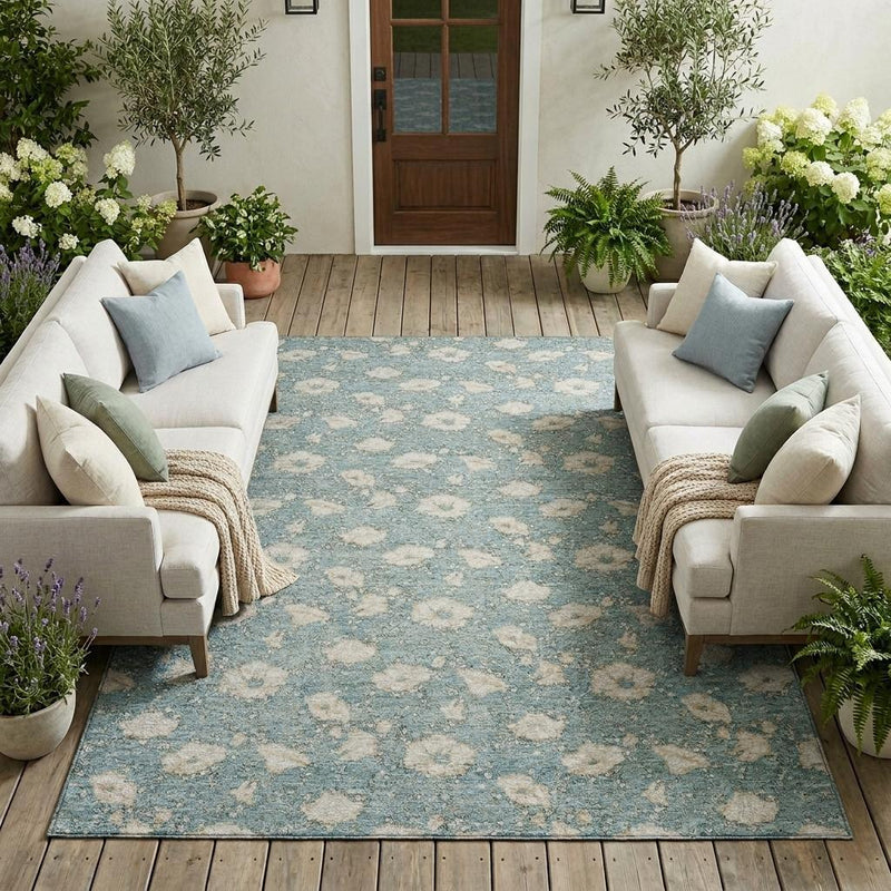 Teal blue floral area rug laid on wood flooring, rectangular with medallion pattern