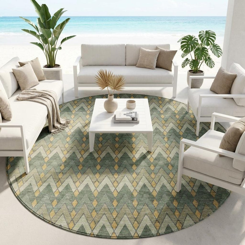 Round geometric area rug with muted green, tan, and gold chevron pattern
