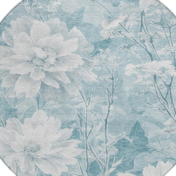 Round light teal floral area rug with white flower silhouettes and botanical vines