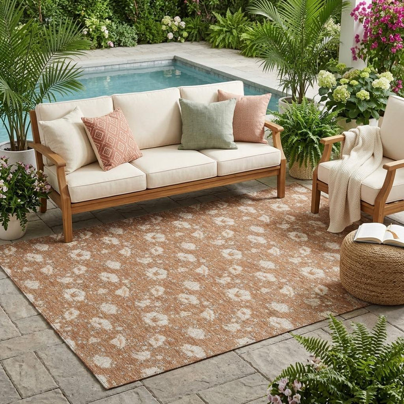 Rust and orange outdoor area rug with cream floral medallion pattern, patio placement