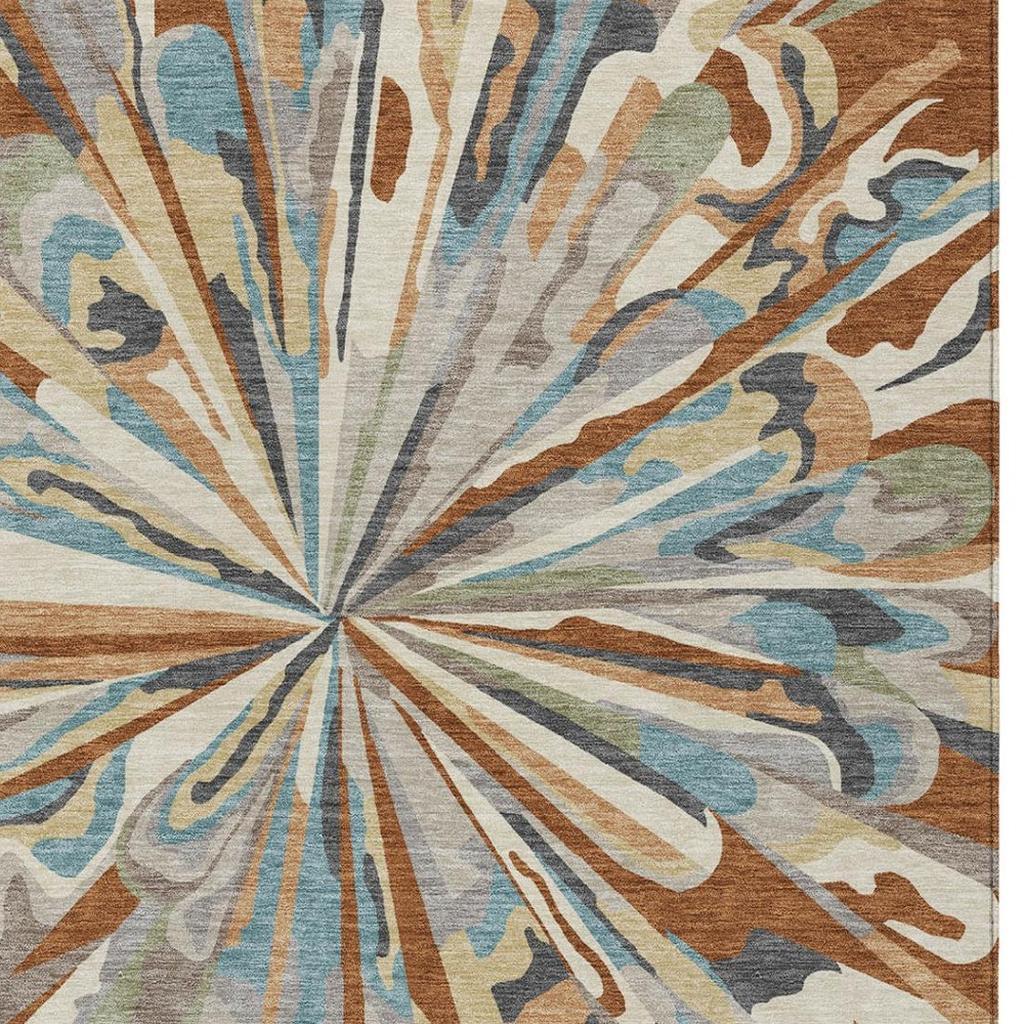 Close-up abstract area rug with radial burst pattern in teal, orange, and neutral beige