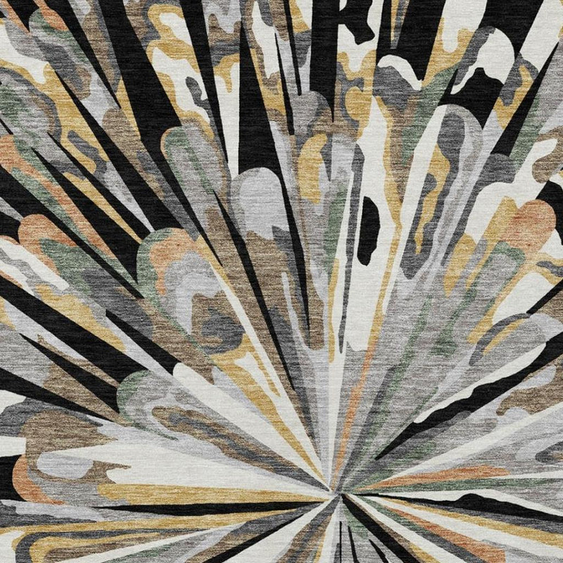 Abstract area rug close-up: sunburst rays in black, gray, and tan with muted gold accents.