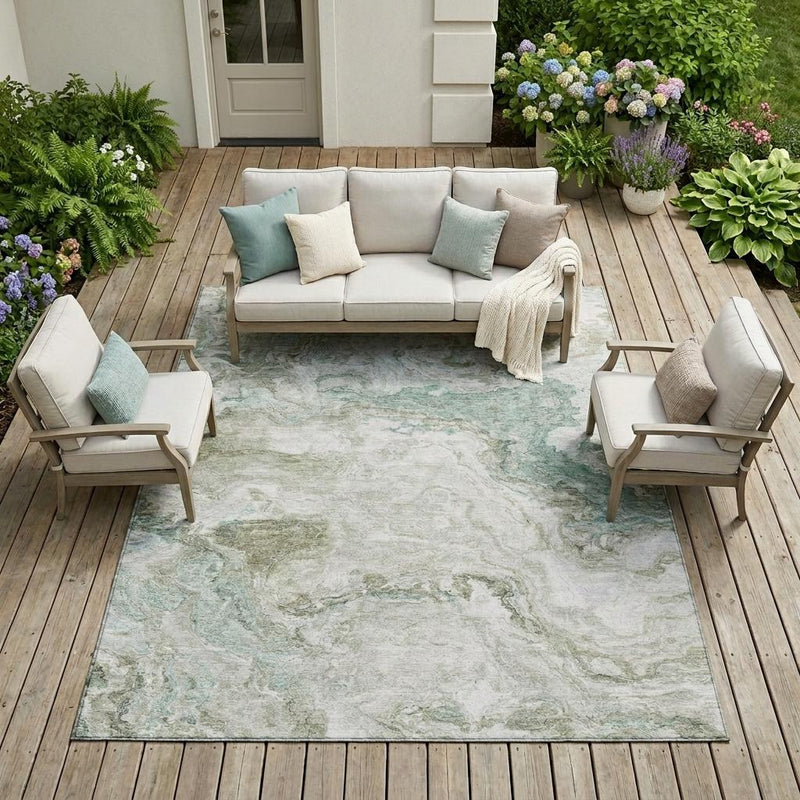 Abstract outdoor area rug with beige field and muted green splash pattern