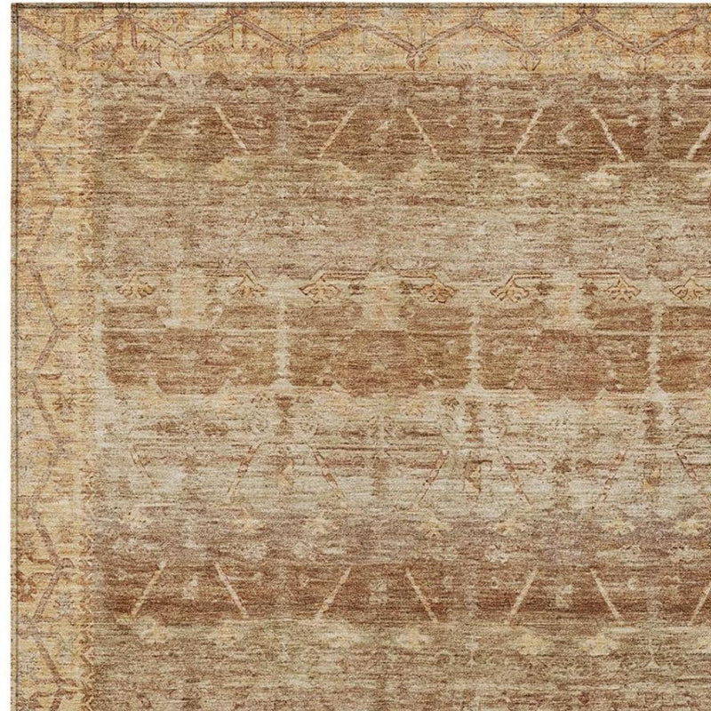 Textured tan area rug surface with faded tribal motifs in copper-brown