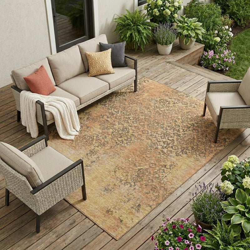 Indoor/outdoor area rug with copper, orange, and beige abstract medallion pattern.