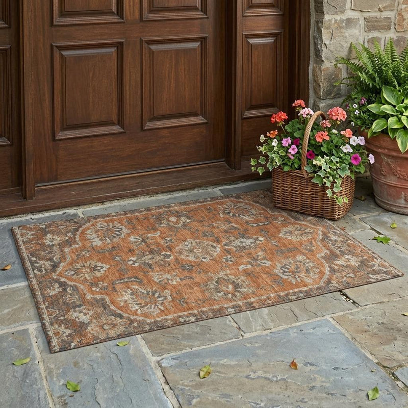 Orange and brown distressed floral medallion area rug with teal and beige details