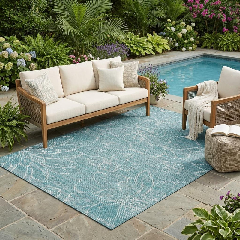 Teal-blue outdoor area rug with white floral wash pattern