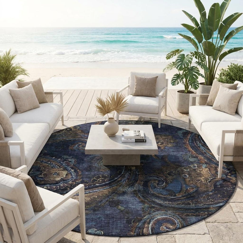 Round paisley area rug, navy blue with beige and teal ornate swirl design.