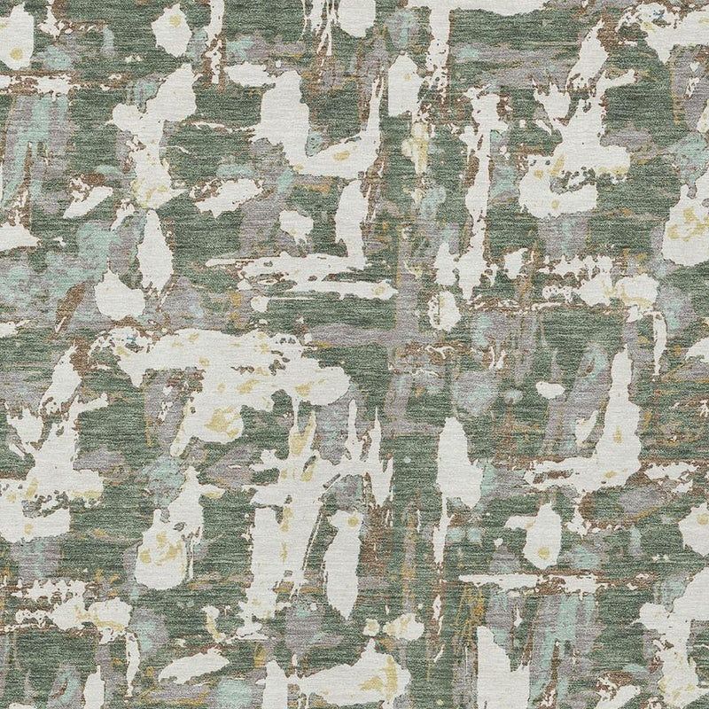 Close-up of area rug texture with layered abstract shapes in green, beige, and off-white