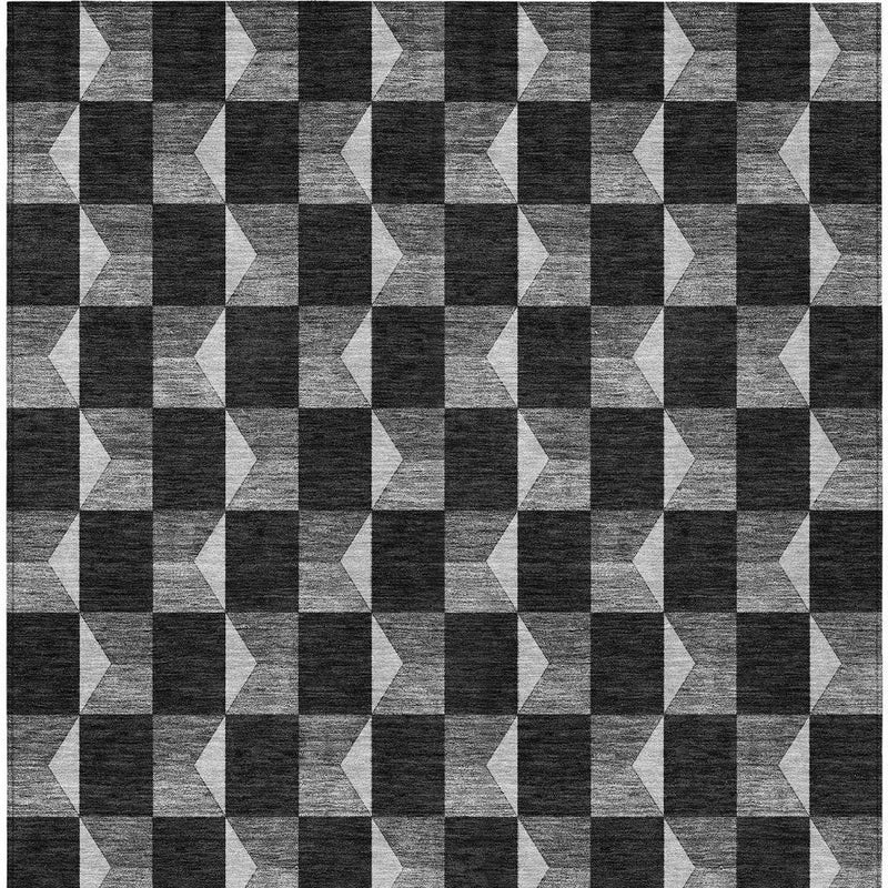 Geometric area rug with repeating black and ivory checker-and-chevron motif