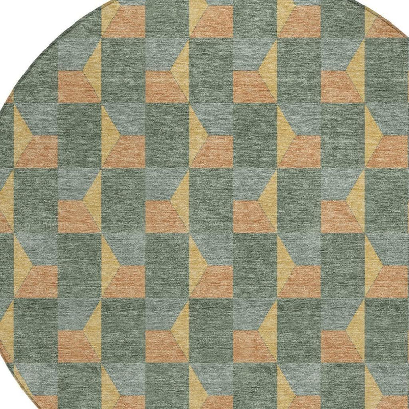 Round green-gray area rug with repeating geometric cube pattern in tan, yellow, and orange