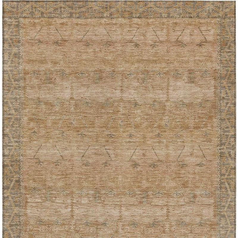 Tan area rug with faded geometric tribal motifs and muted border trim