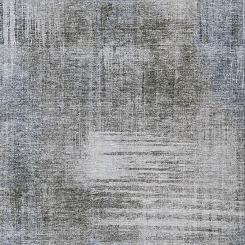 Close-up of abstract distressed area rug showing layered streaks in gray and off-white.